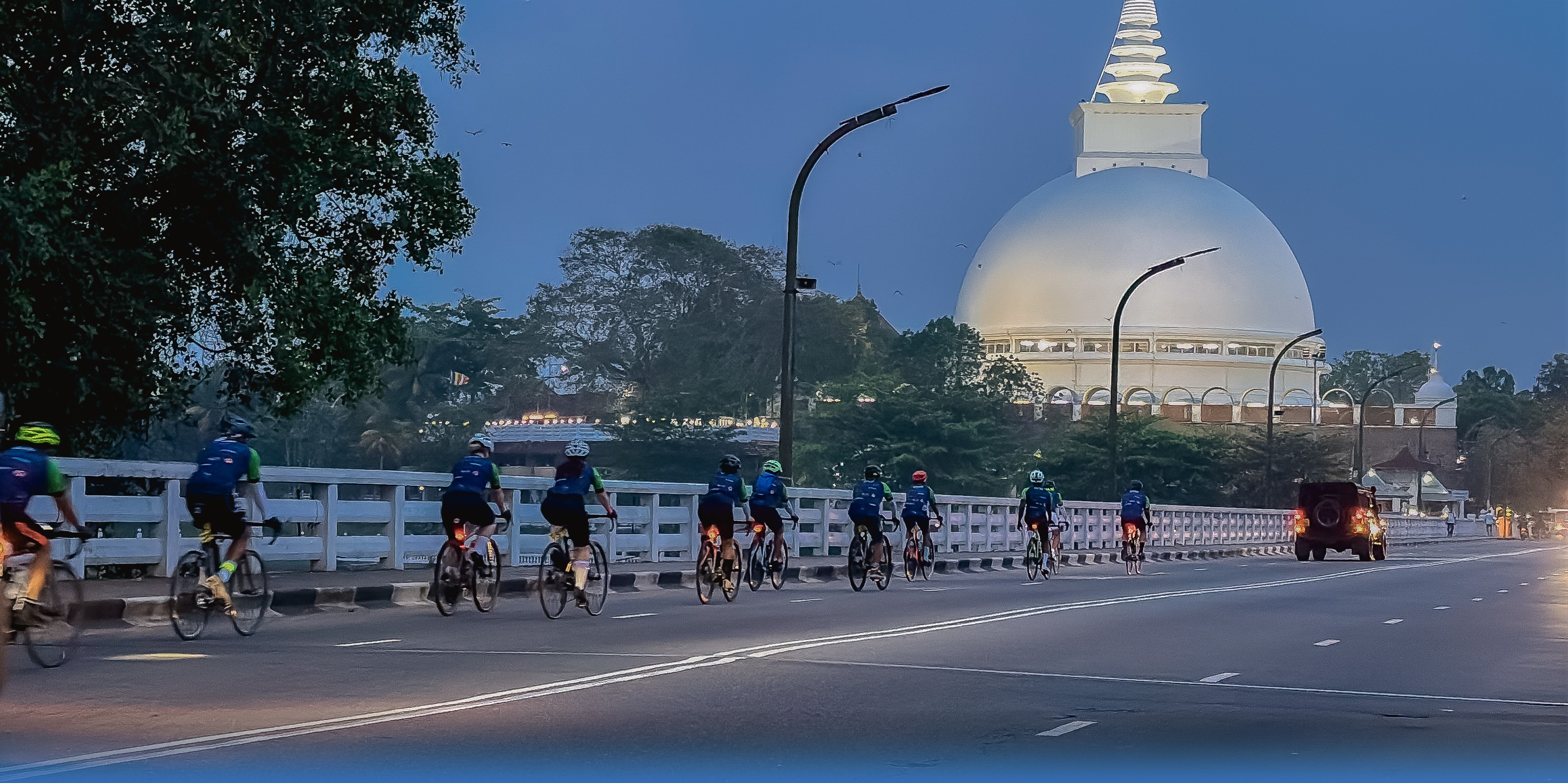 2026 riders cycling across a bridge